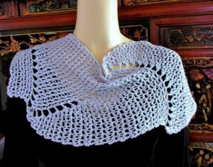 Capelet of lacy beaded slip stitches in a swirl pattern.