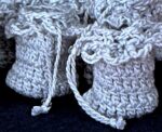 Close up of crochet perfume pouches with twisted drawstring, and slider bead