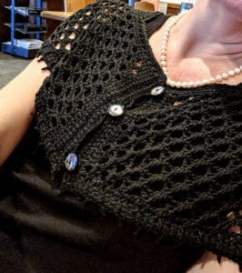 The 3-button front Graven capelet and black dress and pearls.