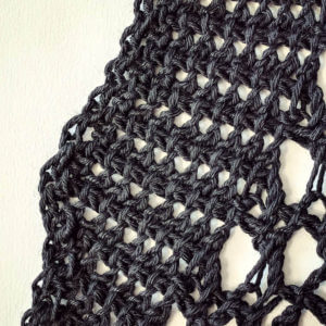 Close up of the change in stitch pattern for the collar, in progress. These are twisted Tunisian crochet stitches in DesigningVashti Lotus yarn, "Black Gleam" color. (It's inky, glossy, deep black but doesn't look like it in this lightened photo.) Close up of the change in stitch pattern for the collar, in progress. These are twisted Tunisian crochet stitches in DesigningVashti Lotus yarn, "Black Gleam" color. (It's inky, glossy, deep black but doesn't look like it in this lightened photo.)