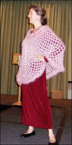 Vashti models a mesh poncho crocheted of a mauve-pink silky angora-like medium weight yarn called Gedifra Micro Chic.