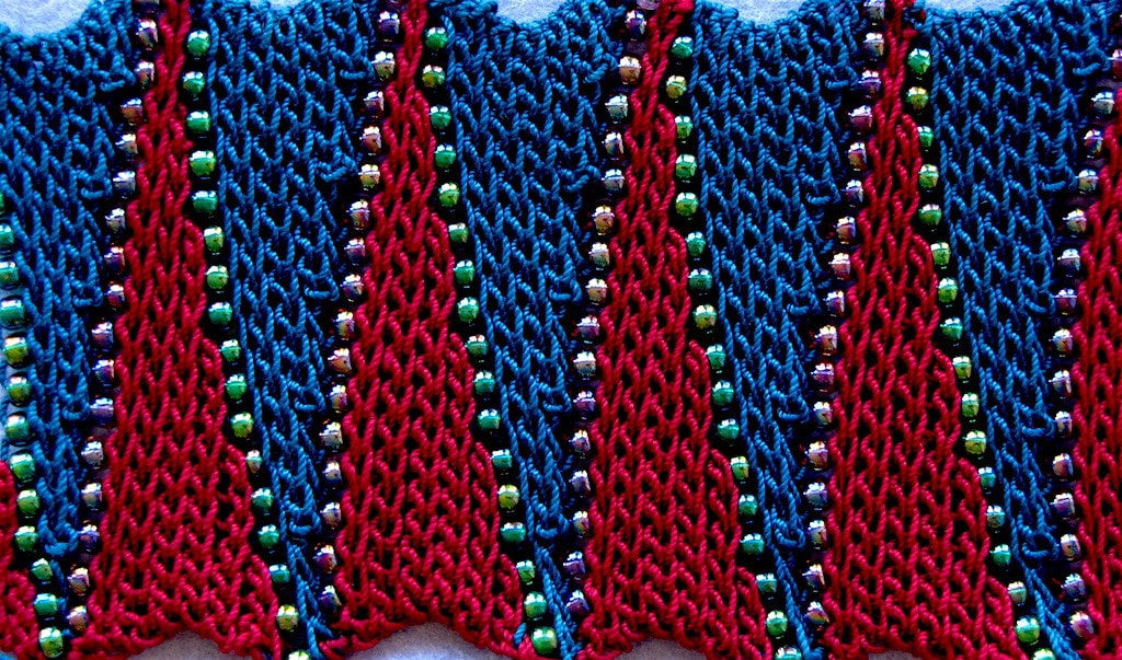 Pattern of short row wedges in alternating colors separated by beads shown flat