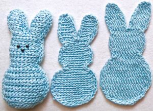 Two flat crochet bunnies and a stuffed one, all "marshmallow peeps style" in light blue Lotus yarn